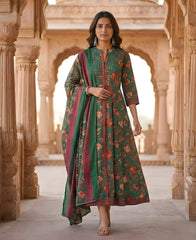 Woman in a green floral dress standing in an architectural setting with intricate carvings.